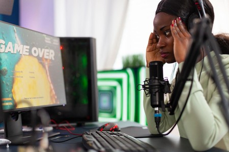 Mwanamke amekaa mbele ya kompyuta akiwa na wasiwasi baada ya kuona ujumbe wa game over.