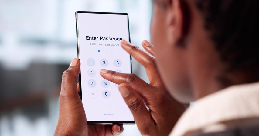 Mtu anaingiza passcode kwenye simu janja, akionyesha hatua ya kulinda kifaa au akaunti kwa nambari ya siri.