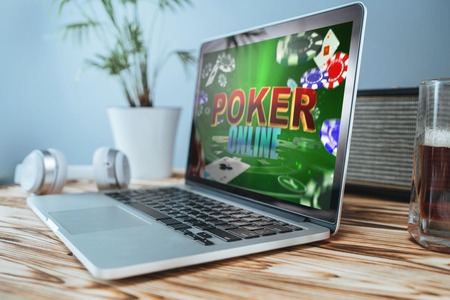 Kompyuta mpakato juu ya meza inaonyesha maandishi ya poker online kwenye skrini.